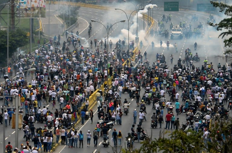 Police fired tear gas and rubber bullets to break up thousands of marchers as they reached a vital freeway in Caracas