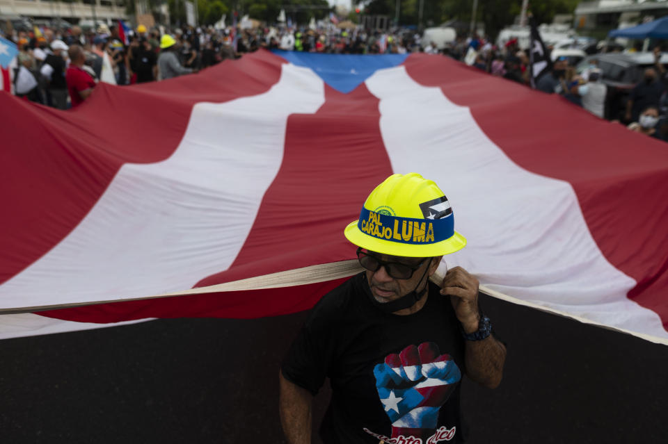 People march along Las Americas Highway to protest the LUMA Energy company in San Juan, Puerto Rico, Friday, Oct. 15, 2021. Ever since LUMA began providing service over the summer, hundreds of thousands of Puerto Ricans have had to deal with widespread blackouts for extended periods of time, voltage fluctuations and bad customer service along with an increase in pricing. (AP Photo/Carlos Giusti)