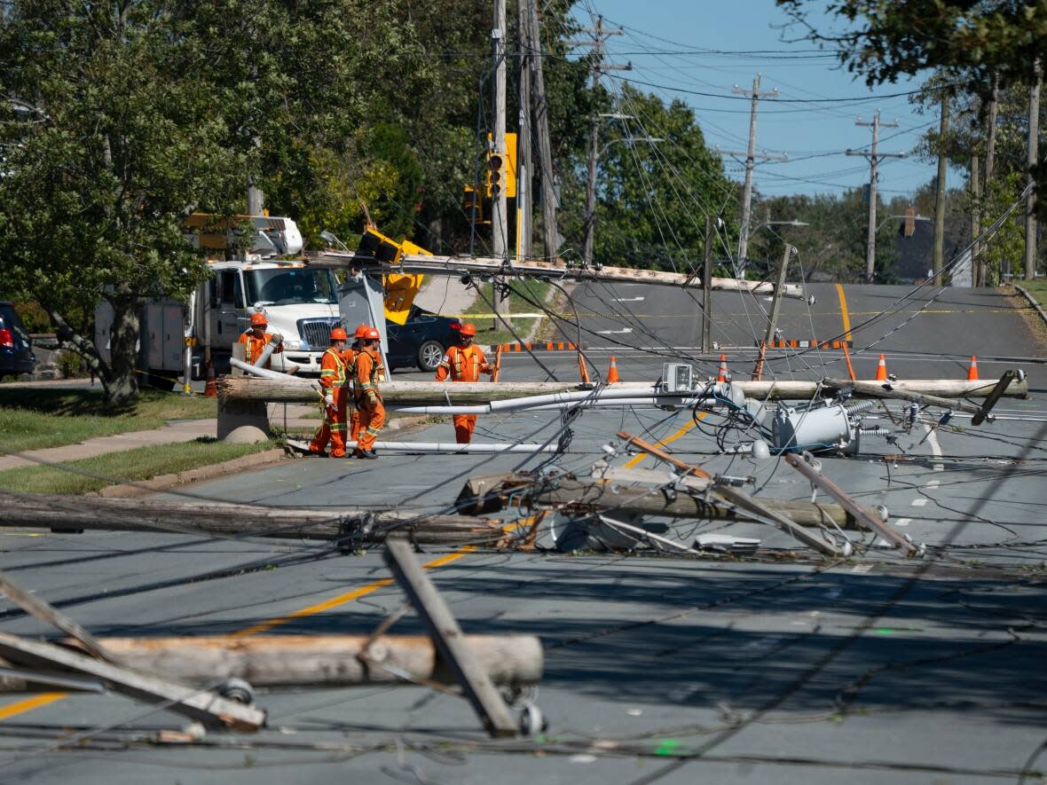 Workers assess downed power poles caused by post-tropical storm Fiona in Dartmouth, N.S., on Sunday, Sept. 25, 2022. (Darren Calabrese/The Canadian Press - image credit)