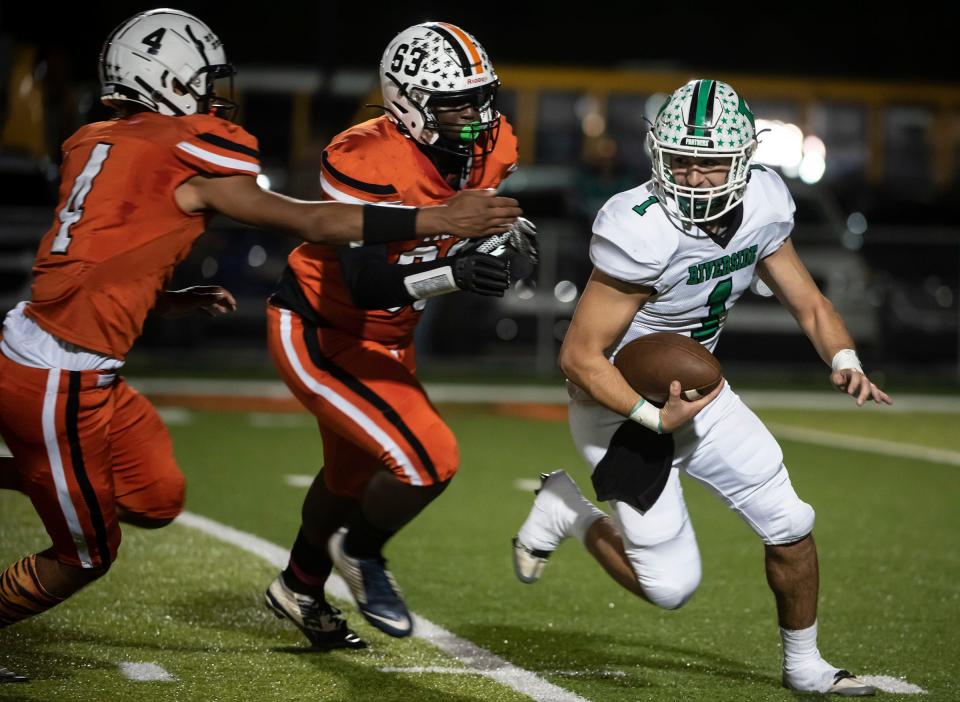 Riverside QB Sam Hughes is chased out of the pocket by two Beaver Falls defenders during their game Friday at Reeves Stadium. [Lucy Schaly/For BCT]