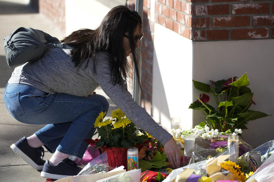 A woman lays down flowers at a memorial outside the Star Ballroom Dance Studio on Monday, Jan. 23, 2023, in Monterey Park, Calif. A gunman killed multiple people at the ballroom dance studio late Saturday amid Lunar New Year's celebrations in the predominantly Asian American community. (AP Photo/Ashley Landis)