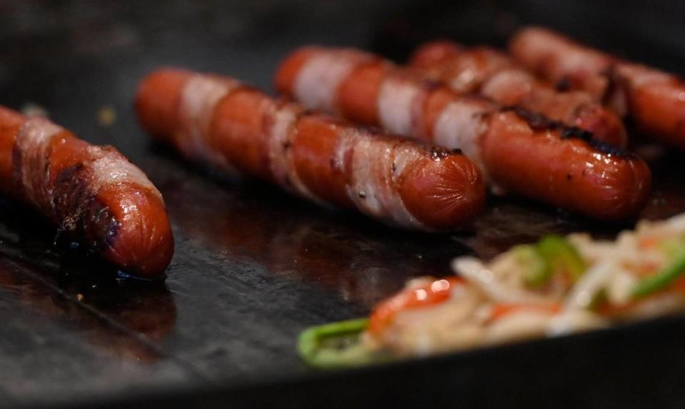 Un vendedor de comida vende hot dogs en la acera de Olive Avenue, en el Distrito Tower en Fresno, el miércoles 19 de julio de 2023.