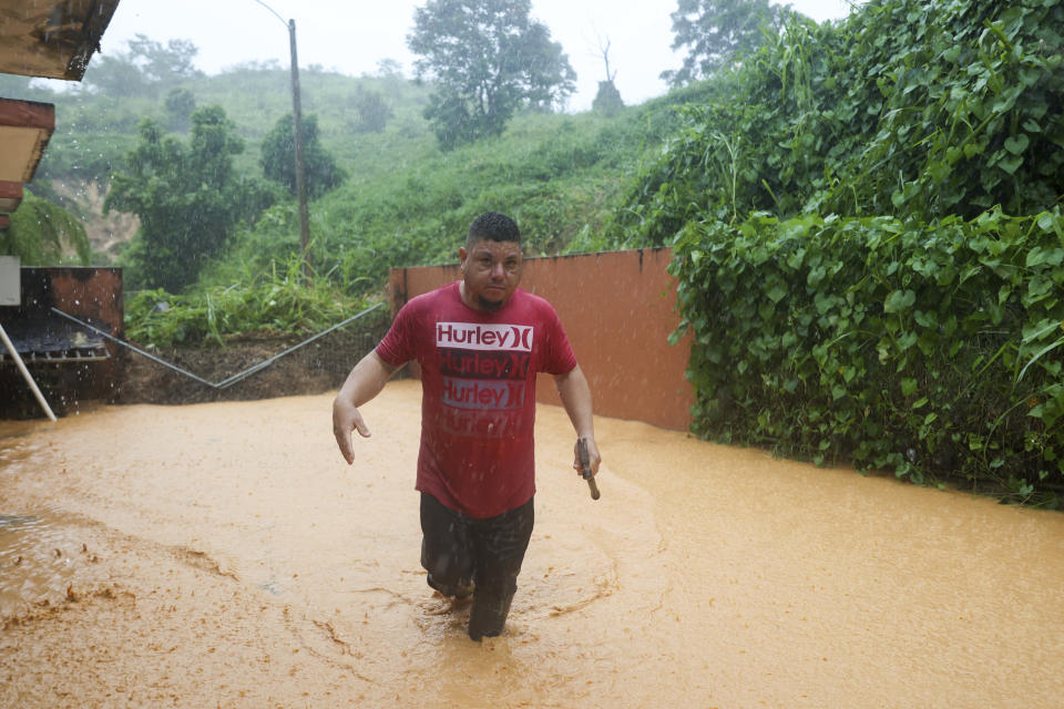 Un hombre camina por una calle inundada por el huracán Fiona en Cayey, Puerto Rico, el domingo 18 de septiembre de 2022. (AP Foto/Stephanie Rojas)