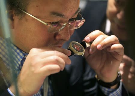 A visitor smells the H. Moser Swiss Mad Watch, the case is made out of cheese, at the Salon International de la Haute Horlogerie (SIHH) watch fair in Geneva, Switzerland, January 17, 2017. REUTERS/Pierre AlbouyEUTERS/Pierre Albouy