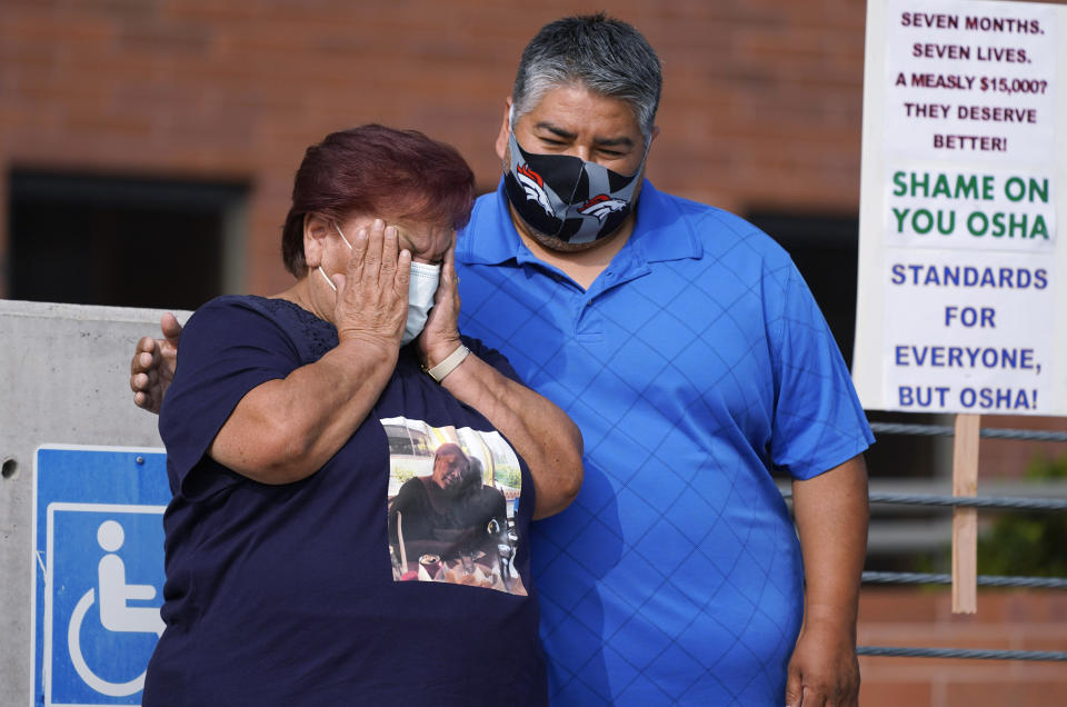 Carolina Sanchez, left, is comforted by her oldest son, Saul Jr., during a protest on  Sept. 16, 2020, in downtown Denver that was staged by the union representing employees at a Colorado meatpacking plant where six workers died of COVID-19 and hundreds more were infected.  (Photo: AP Photo/David Zalubowski)