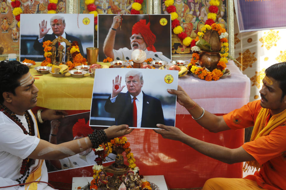 Hindu priests offer prayers holding a portrait of U.S. President Donald Trump in New Delhi, India, Monday, Feb. 24, 2020. The prayer event was held by Hindu Sena for a successful Trump visit and for world peace. (AP Photo/Manish Swarup)