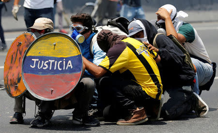 FILE PHOTO: Opposition supporters use a shield that reads "Justice" as they clash with security forces during a rally against Venezuela's President Nicolas Maduro in Caracas, Venezuela April 26, 2017. REUTERS/Carlos Garcia Rawlins/File Photo