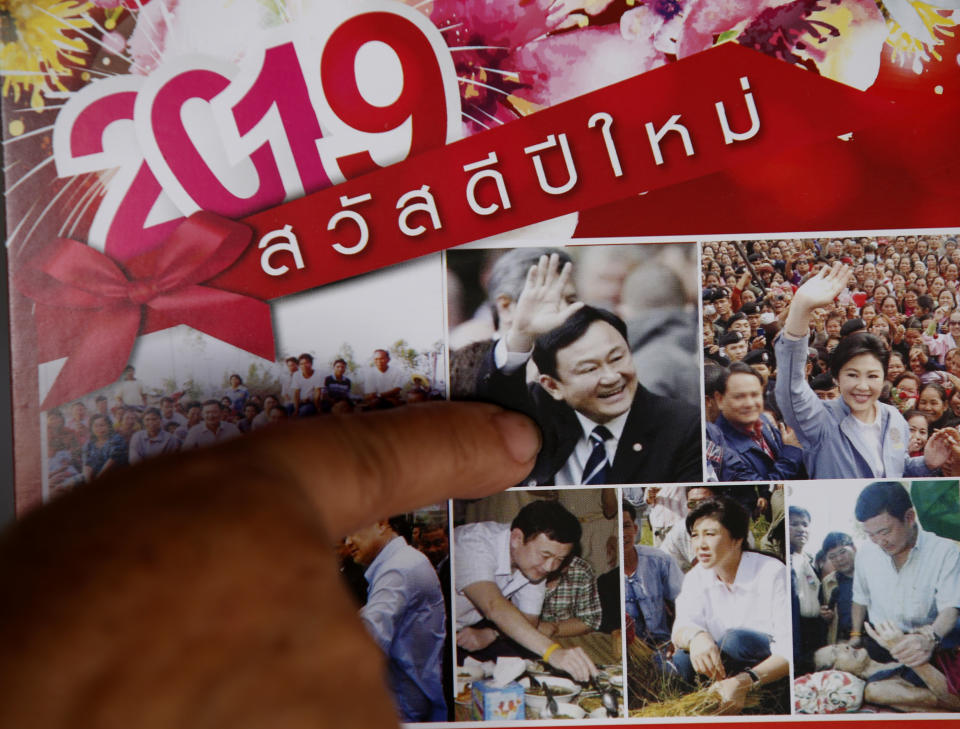 In this March 14, 2019, photo, Nuwate Jiamwong, 59-year-old farmer, points at an image of former Prime Minister Thaksin Shinawatra on a calendar in Nakhon Ratchasima, Thailand. Thailand’s former Prime Minister Thaksin Shinawatra is in exile and banned from interfering in the country’s politics. But his name is a powerful political attraction and in tribute, and to win votes, some candidates in general election on Sunday, March 24, 2019 have changed their names to Thaksin so supporters of the former leader can register their loyalty at the ballot box. "No matter what anyone said about him, I always loved him since many years ago," says the farmer. (AP Photo/Sakchai Lalit)