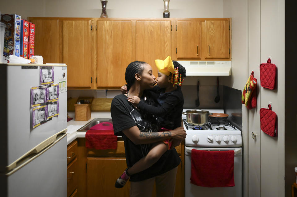 Shanta Russ, 22, kissed her daughter, Siya Freeman, 4, after being allowed back up to her father's 15th floor apartment, following a fire on the 14th floor in Minneapolis on Wednesday, Nov. 27, 2019. Several people died and three were injured when the fire broke at the public housing high-rise in a heavily immigrant neighborhood of Minneapolis early Wednesday. (Aaron Lavinsky/Star Tribune via AP)