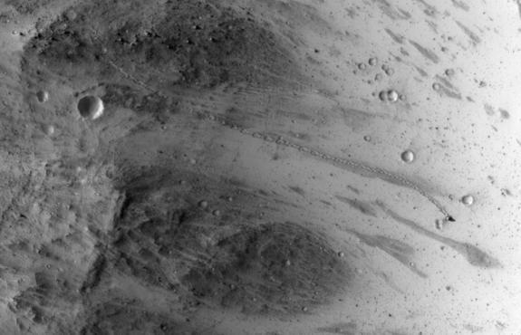 NASA's Mars Reconnaissance Orbiter snapped this view, showing the the trail left by a rolling boulder that tumbled down the side of a slope., on July 3, 2014.