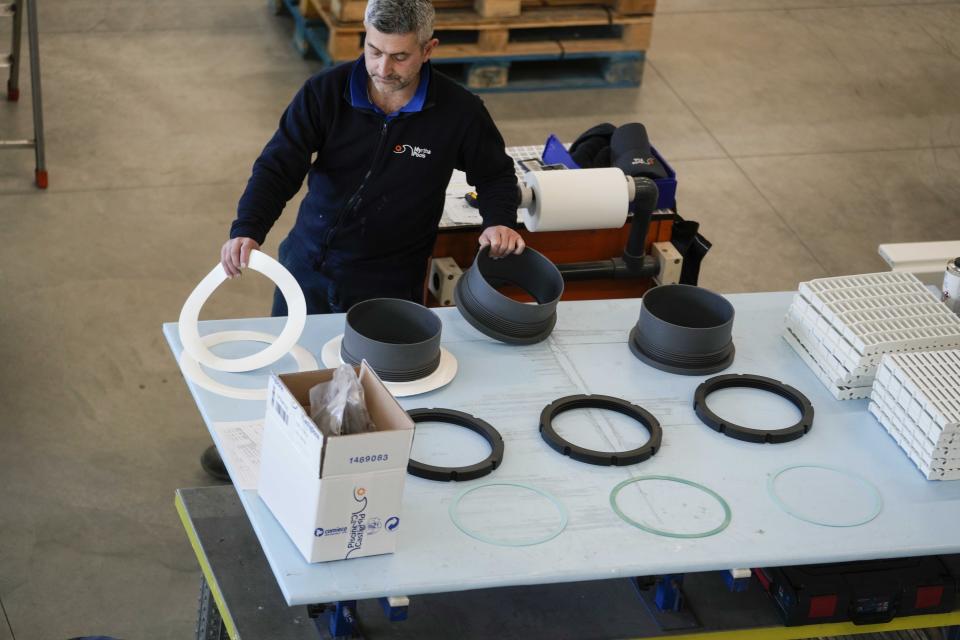 A worker arranges pool lights at the Myrtha Pools factory, in Castiglione delle Stiviere, northern Italy, Tuesday, March 12, 2024. Italian company Myrtha Pools is producing 24 pools for the Paris Olympics at its factory in Castiglione delle Stiviere, near Verona. The pools will be used for swimming, diving, water polo, artistic swimming and training areas in Paris. It's the sixth Olympics that Myrtha will be providing pools for. (AP Photo/Luca Bruno)