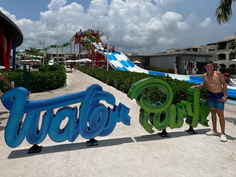 boy standing next to a water park slide at an all inclusive resort