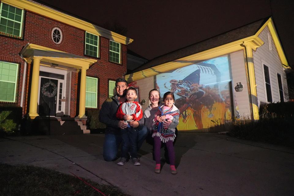 Powell homeowner Edgar Escobar's latest holiday light display pays homage to the MLS Cup champion Columbus Crew. From left are Escobar, his 3-year-old son Xander, wife Megan, and 4-year-old daughter Melianna.