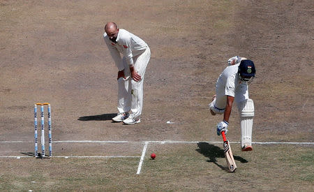 India's Cheteshwar Pujara successfully completes a run as Australia's Nathan Lyon watches. REUTERS/Adnan Abidi