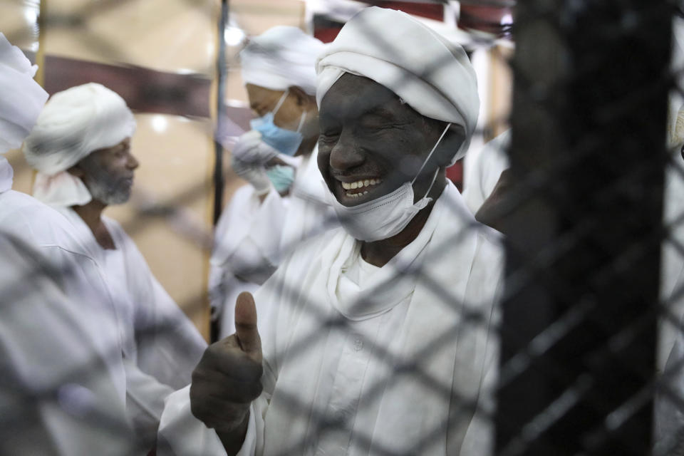 Former Sudanese vice president Ali Ossman Taha gestures behind bars during the trial of ousted Sudanese president Omar al-Bashir and over two dozen former top officials, in Khartoum, Sudan, Tuesday, July 21, 2020. The 76-year-old al-Bashir has been jailed in Khartoum since his ouster, facing several separate trials related to his rule and the uprising that helped oust him. Al-Bashir is also wanted by the International Criminal Court on charges of war crimes and genocide linked to the Darfur conflict in the 2000s. (AP Photo/Marwan Ali)