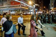 Locals pass police in riot gear during a standoff with protesters in Mong Kok in Hong Kong