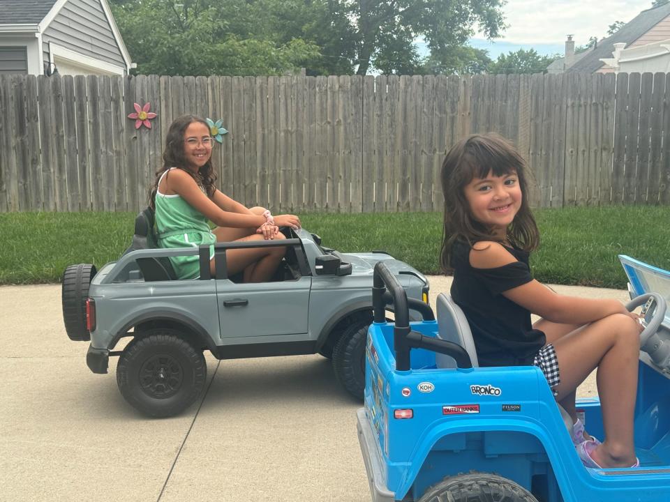 Tala Young, 9, and Kaya Young, 5, of Royal Oak drive their Broncos around their home on June 26, 2024.