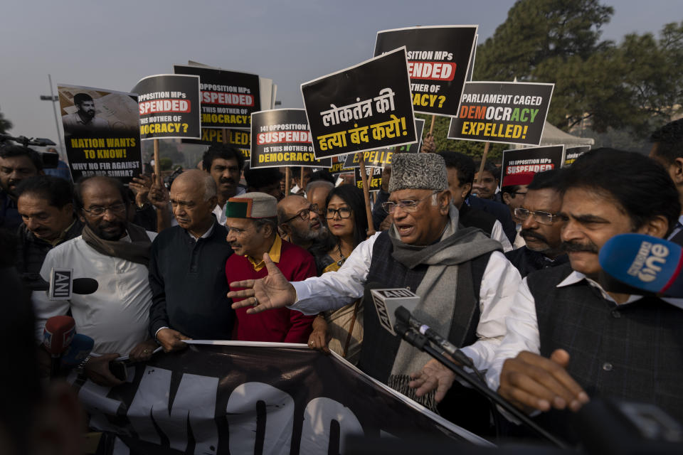 Congress party President Mallikarjun Kharge, wearing hat, addresses the media after suspended lawmakers marched outside the Parliament House in New Delhi, India, Thursday, Dec. 21, 2023. Dozens of opposition lawmakers suspended from Parliament by Prime Minister Narendra Modi's government for obstructing proceedings in the chamber held a street protest on Thursday accusing the government of throttling democracy in the country. (AP Photo/Altaf Qadri)