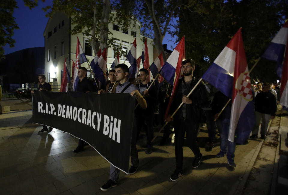 People hold a banner reading "RIP Democracy BiH" during protest in Mostar, Bosnia, Thursday, Oct. 11, 2018. Several thousand Bosnian Croat nationalists have protested the election victory of a moderate politician last weekend in the race for the Croat seat in Bosnia's three-person presidency. The crowd Thursday marched through the ethnically divided southern town of Mostar holding banners reading "Not my president" and "RIP democracy" in protest at the election of Zeljko Komsic." (AP Photo/Amel Emric)