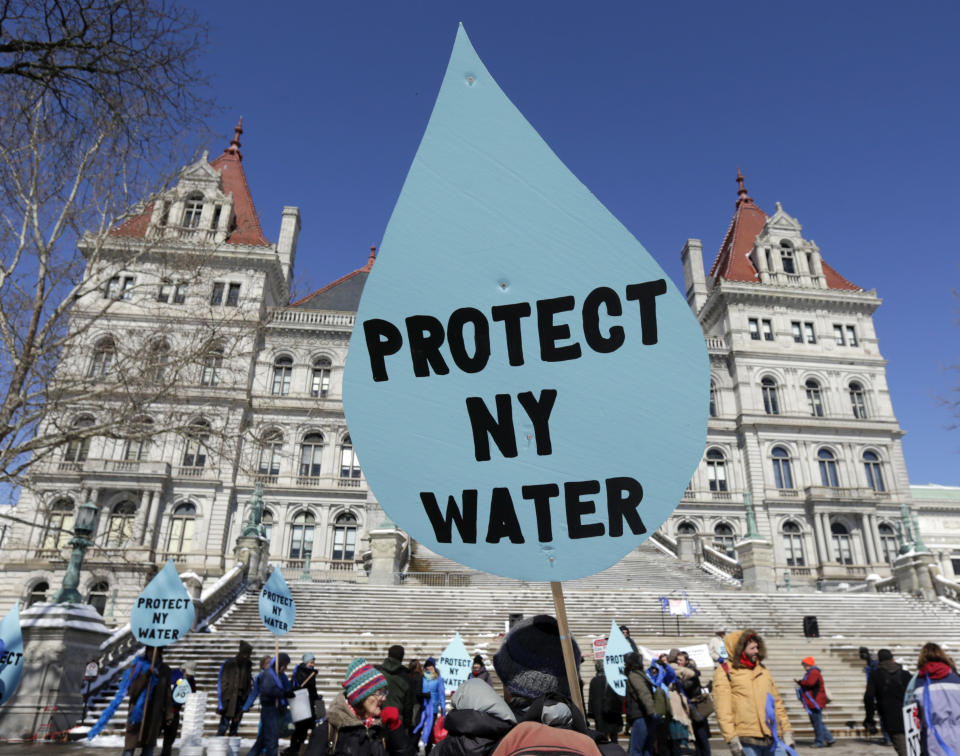 FILE - In this April 5, 2016 file photo, a man carries a sign before a rally opposing the Constitution Pipeline outside the state Capitol in Albany, N.Y. The nearly $1 billion Constitution Pipeline project that was designed to bring natural gas from Pennsylvania's shale gas fields to metropolitan New York and New England has been abandoned after years of legal regulatory challenges made it economically unfeasible, according to a statement Monday from a spokeswoman for project partner Duke Energy said Monday, Feb. 24, 2020. (AP Photo/Mike Groll, File)