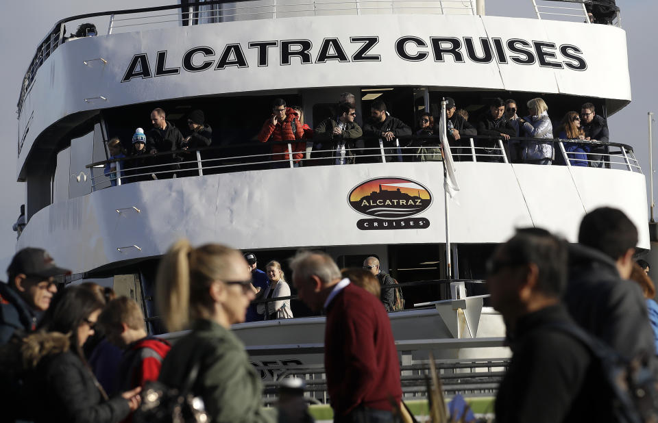 An Alcatraz Cruise ship waits to depart as customers stand in line for ferry service in San Francisco, Saturday, Dec. 22, 2018. A partial federal shutdown has been put in motion because of gridlock in Congress over funding for President Donald Trump's Mexican border wall. The company that provides ferry services to Alcatraz Island kept its daytime tours but canceled its behind-the-scenes and night tours for Saturday. (AP Photo/Jeff Chiu)