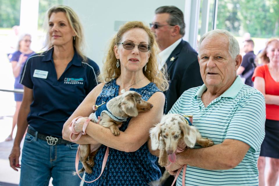 Eileen Douglas with Lily and Gordon Douglas with Lucy enter the lobby as the UF Veterinary Hospital at WEC opened with a ribbon cutting Wednesday.