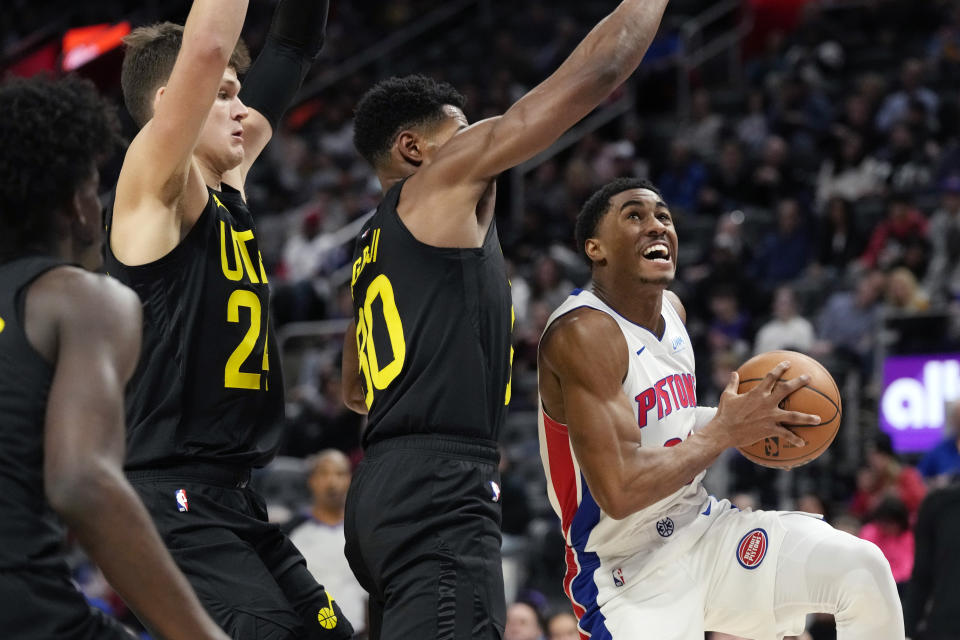 Detroit Pistons guard Jaden Ivey (23) is defended by Utah Jazz center Walker Kessler (24) and guard Ochai Agbaji (30) during the first half of an NBA basketball game, Thursday, Dec. 21, 2023, in Detroit. (AP Photo/Carlos Osorio)