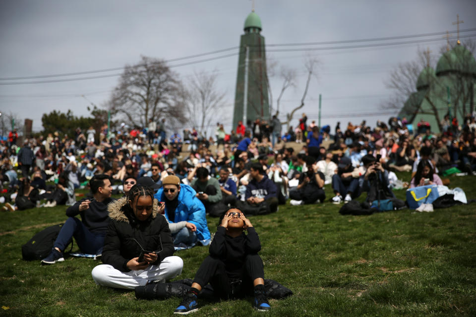 People gather to view the solar eclipse at Riverdale Park on April 8, 2024 in Toronto, Ontario. (Photo by Maryam Majd/Getty Images)