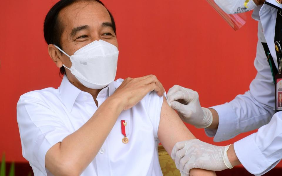 Indonesian President Joko Widodo reacts after receiving a shot of Covid-19 vaccine at the Merdeka Palace in Jakarta - Muchlis Jr/Presidential Palace