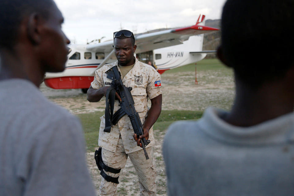 <p>A police officer stands guard in front of a plane loaded with food at the airport after Hurricane Matthew passes Jeremie, Haiti, October 7, 2016. (REUTERS/Carlos Garcia Rawlins)</p>