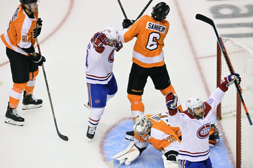 Montreal Canadiens left wing Tomas Tatar (90) celebrates his goal against Philadelphia Flyers goaltender Carter Hart (79) as Canadiens right wing Brendan Gallagher (11) and Flyers defenseman Travis Sanheim (6) battle in front of the net during first period of NHL Eastern Conference Stanley Cup first round playoff action in Toronto on Friday, Aug. 14, 2020. (Frank Gunn/The Canadian Press via AP)