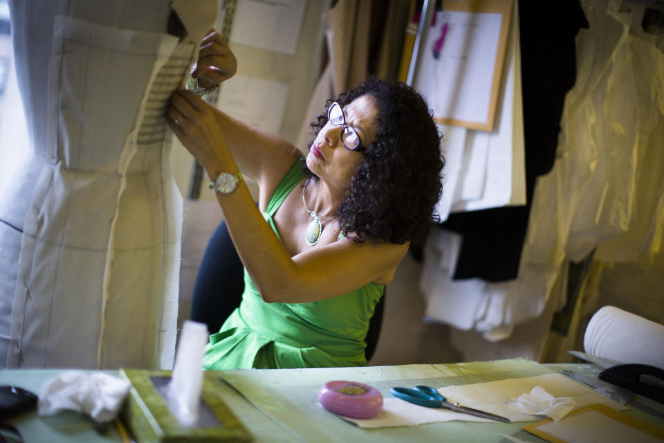 In this Aug 22, 2013 photo, pattern maker Luz Pyne pins cloth to a mannequin at the New York studio of fashion designer Carmen Marc Valvo. Valvo will show his Spring 2014 collection on Sept. 6 at Lincoln Center in New York. (AP Photo/John Minchillo)