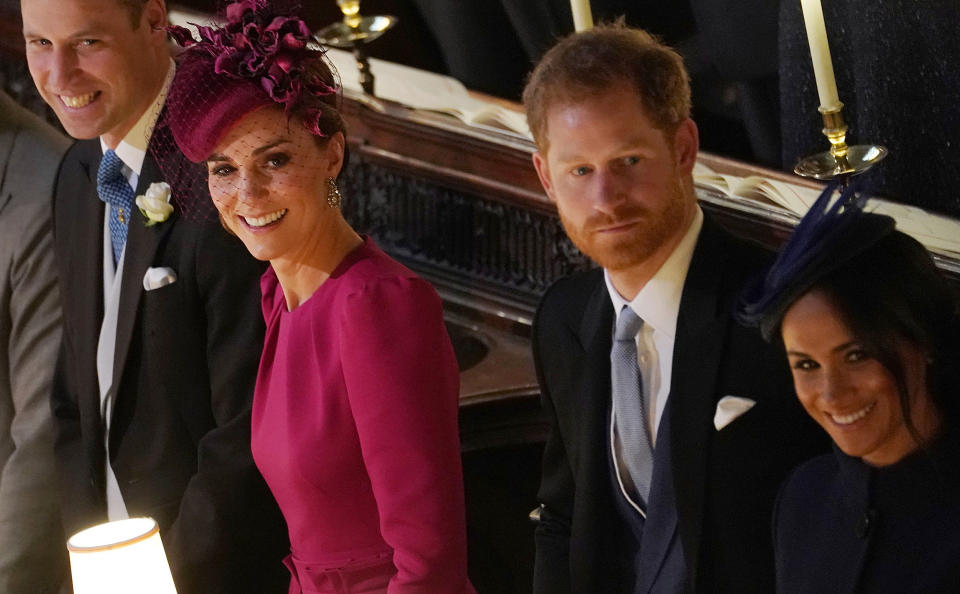 Britain's Prince William, Duke of Cambridge (L) Britain's Catherine, Duchess of Cambridge (2L), Britain's Prince Harry, Duke of Sussex and Meghan, Duchess of Sussex react during the wedding ceremony of Britain's Princess Eugenie of York and Jack Brooksbank at St George's Chapel, Windsor Castle, in Windsor, on October 12, 2018. (Photo by Owen Humphreys / POOL / AFP)        (Photo credit should read OWEN HUMPHREYS/AFP/Getty Images)