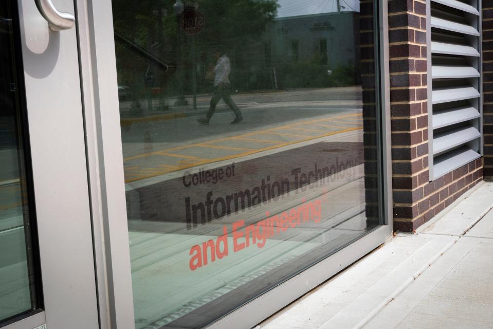 A person is reflected in the window of the new Baker College campus while crossing the street near South Lafayette Avenue in Royal Oak on Thursday, Sept. 7, 2023.