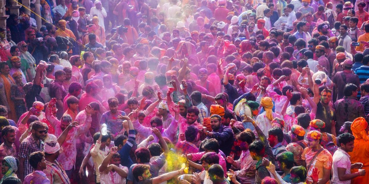 large crowds of hindu devotees celebrating holi in temple at nandgaon