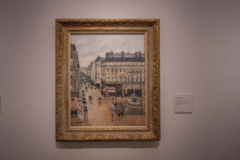 Una mujer mira la pintura impresionista "Rue St.-Honore, Apres-Midi, Effet de Pluie" (“Calle Saint-Honoré por la tarde, efecto de lluvia”) de Camille Pissarro de 1897 en el Museo Thyssen-Bornemisza en Madrid, España, el 22 de abril de 2022. El museo nacional español dijo el viernes 22 de abril que confía que los tribunales estadounidenses dicten una vez más que la valiosa pintura francesa impresionista, que fue robada a una familia judía por los nazis, pertenece al museo y no a los descendientes de la familia. (Foto AP/Manu Fernández)