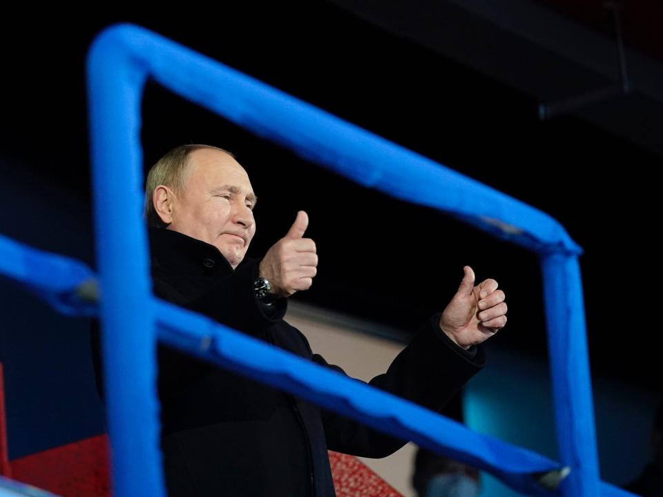 Russian President Vladimir Putin stands and gestures as the Russian Olympic Committee athletes arrive at this year's Opening Ceremony.