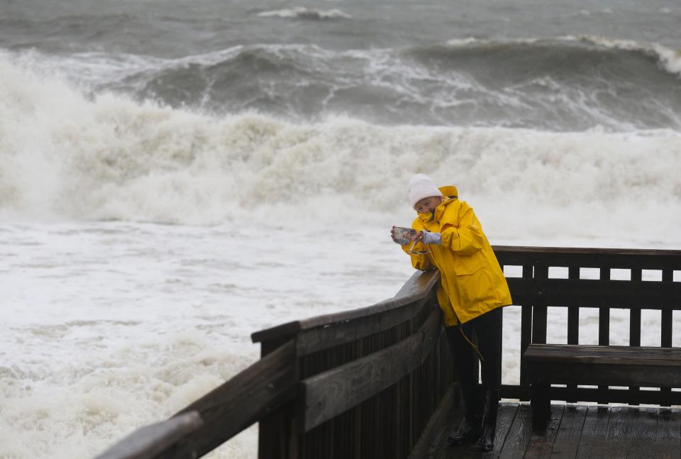 Patti Riffle of Lewes photographs the foamy remnants of heavy surf as she examines the storm-churned surf at Cape Henlopen State Park as tropical storm Ophelia hit the Delaware coast  Sept. 23, 2023.