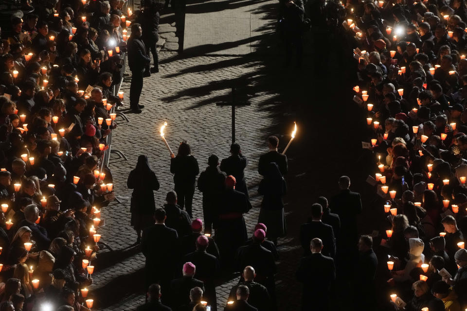 Faithful hold the cross as they take part in the Via Crucis (Way of the Cross) torchlight procession at the Colosseum on Good Friday, in Rome, Friday, April 7, 2023. The Vatican sayd Pope Francis won't go to the Colosseum for the traditional Good Friday procession but instead he will watch it from his home at the Vatican due to unseasonably cold nighttime temperatures in Rome. (AP Photo/Gregorio Borgia)