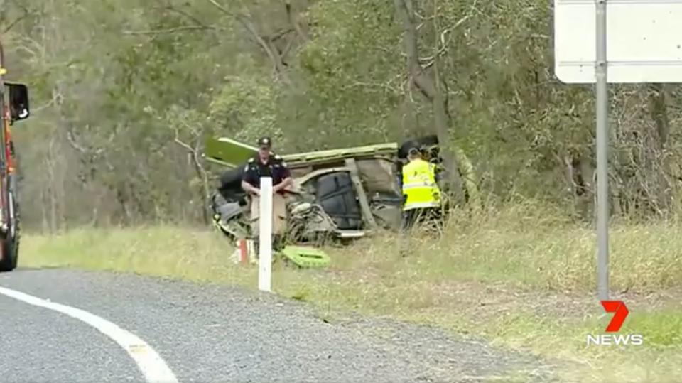 Police investigate an overturned car off Childers Road at South Bingera. Three people died in a three-car crash on Sunday morning.