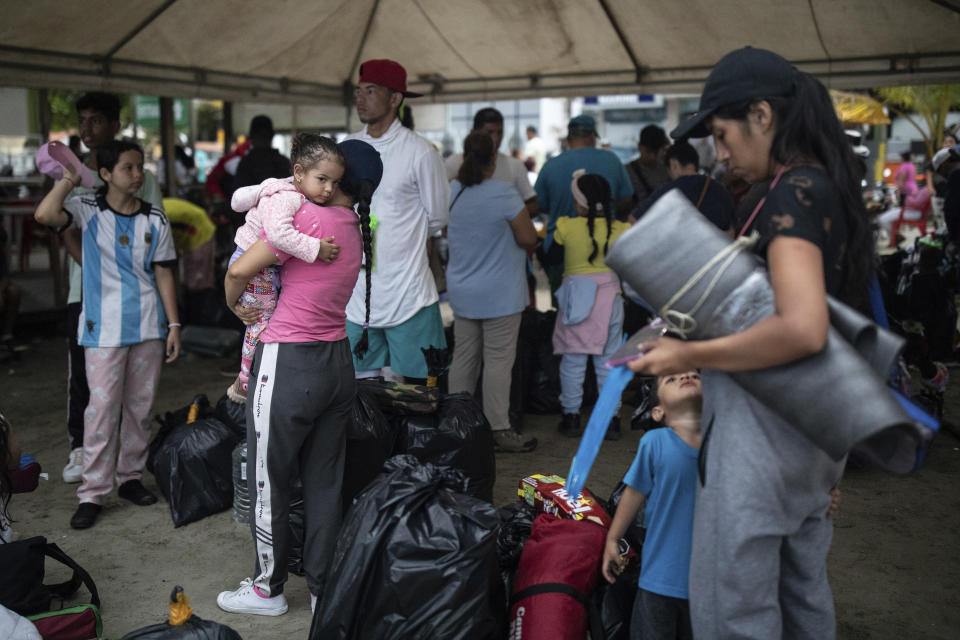 Migrantes esperan para subir a un bote en Necoclí, Colombia, el sábado 7 de octubre de 2023. (AP Foto/Iván Valencia)