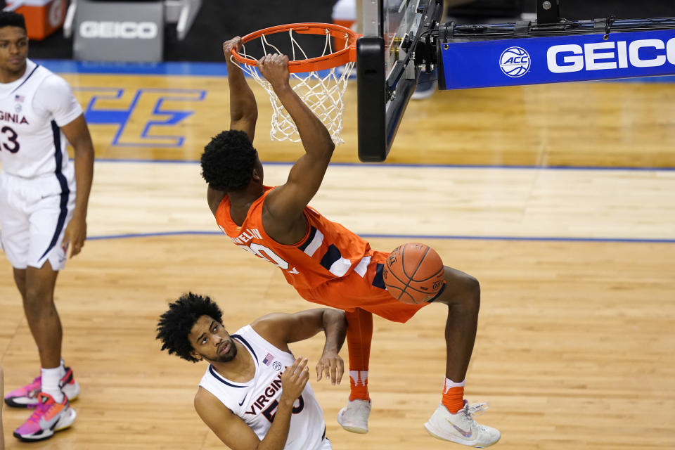 Syracuse forward Robert Braswell (20) dunks over Virginia guard Tomas Woldetensae (53) during the first half of an NCAA college basketball game in the quarterfinal round of the Atlantic Coast Conference tournament in Greensboro, N.C., Thursday, March 11, 2021. (AP Photo/Gerry Broome)