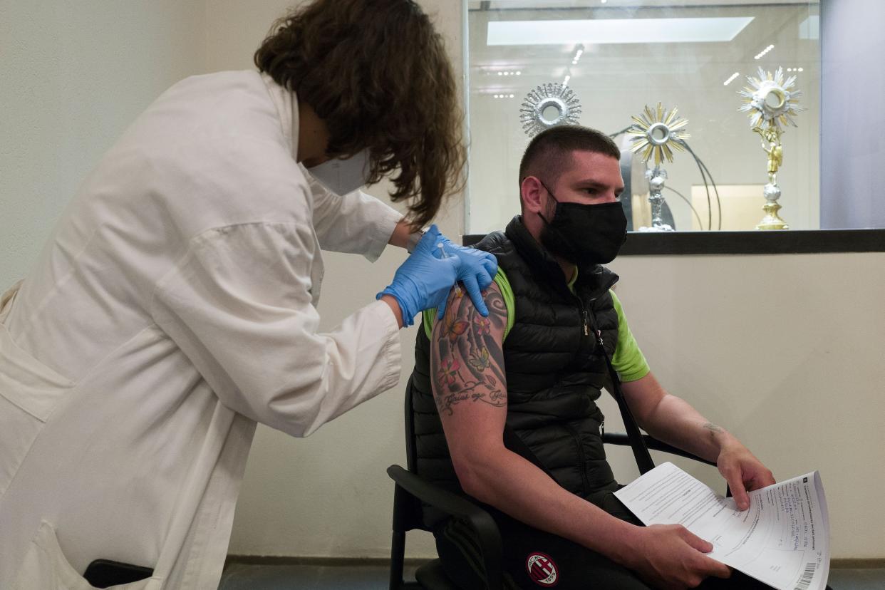 A doctor vaccinates a man in front of some sacred monstrances on display at the MuMe-Museo Regionale in Messina during VACCINArte's "discover, be excited and vaccinate" event on June 10, 2021. VACCINArte, the joint initiative between the Regional Health Department and that of Cultural Heritage and Sicilian Identity, aims to encourage inoculations against the COVID-19 virus as well as promote Sicilian art and museum heritage.