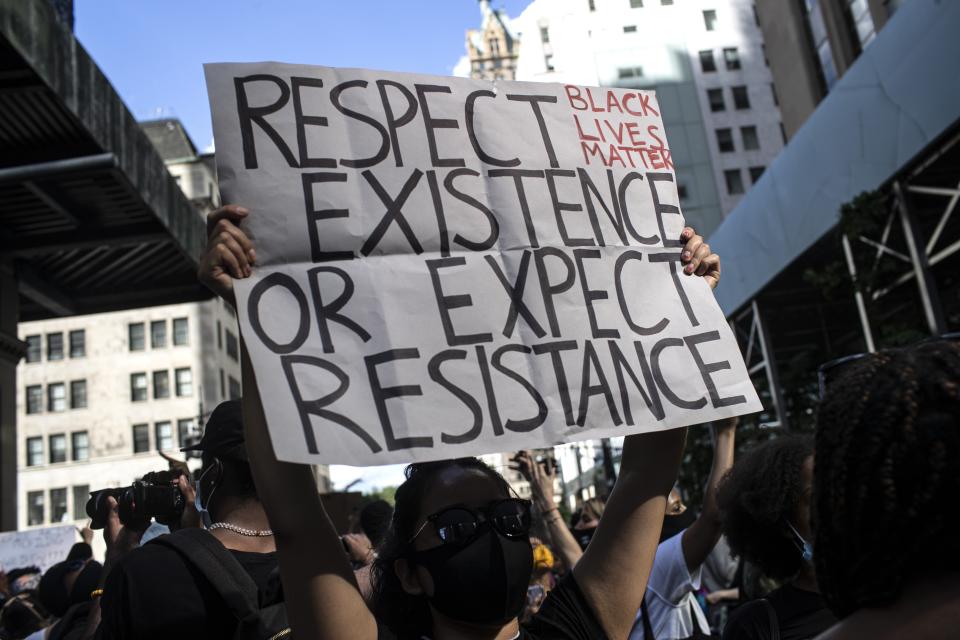 Protesters hold up signs as they march down during a solidarity rally for George Floyd, Saturday, May 30, 2020, in New York. Demonstrators took to the streets of New York City to protest the death of Floyd, a black man who was killed in police custody in Minneapolis on May 25. (AP Photo/Wong Maye-E)