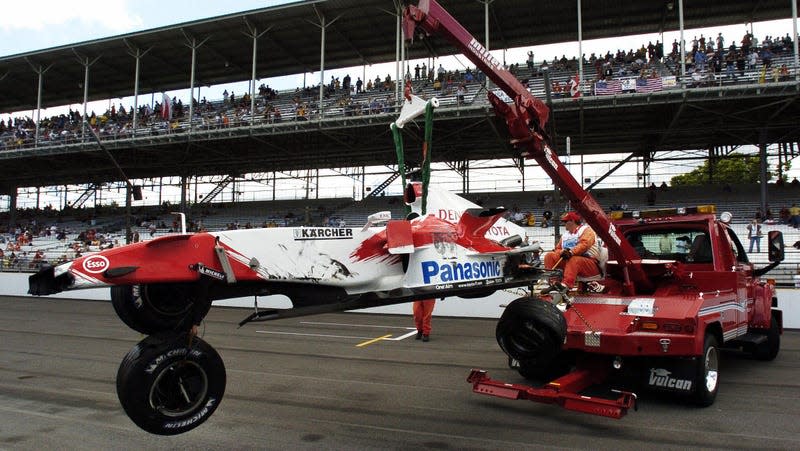Workers collect Ralf Schumacher’s Toyota after it blew a left-rear tire at the 2005 US GP.