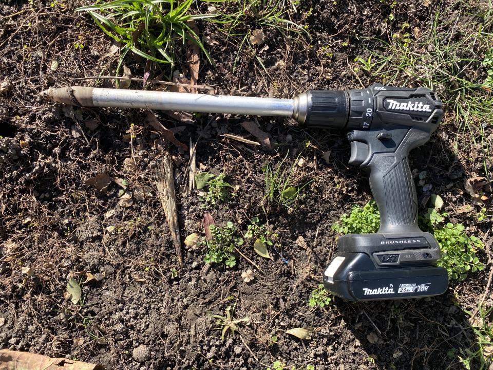 Soil measurement tool by Yard stick lying on ground