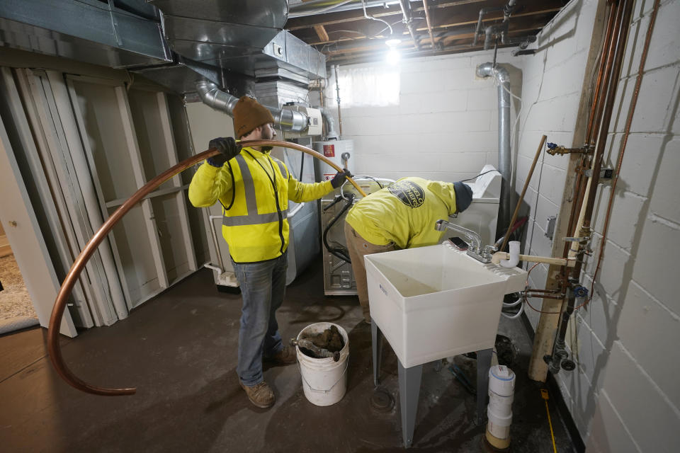 Acrew pushes new copper tubing as they replace the lead water main at a home in Royal Oak, Mich., on Tuesday, Nov. 16, 2021. Communities with lead pipes could see higher test results for lead in their tap water if a new method of water sampling goes into effect. The Detroit suburb of Royal Oak historically had low test results but it had to notify the public of a problem after the state mandated new sampling methods. (AP Photo/Carlos Osorio)