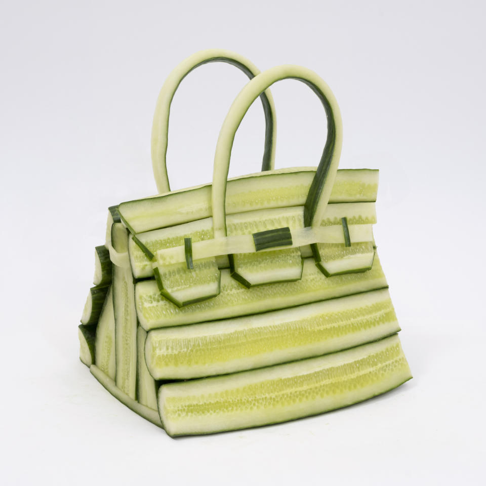 a photo of a birkin bag made from green cucumbers against a white background