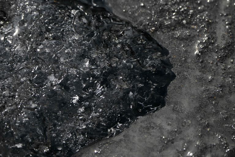 Un detalle de limo y escombros que fluyen alrededor de una capa de hielo derretido en el glaciar 
