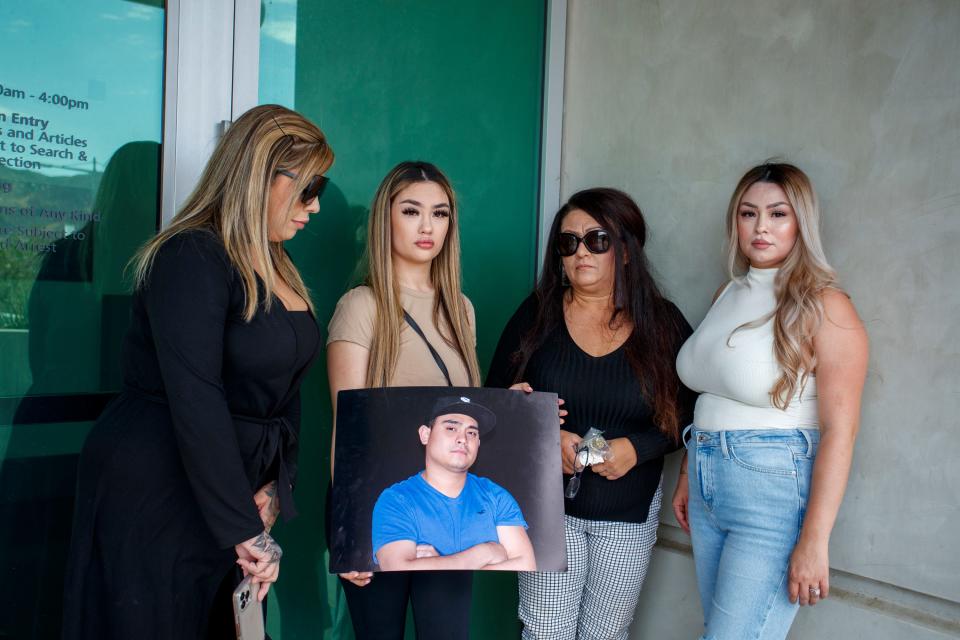 A photograph of Richard Matus Jr. who died in a Riverside County jail last week is held by his sister Lisa Marie as his other sisters Candace Cortez, left, Rachel Morales and their mother Lisa Matus look on outside the Banning Justice Center in Banning, Calif., on August 19, 2022.